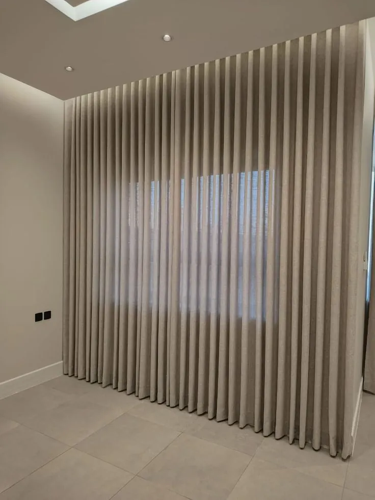 Grey linen wave curtains closed across a full wall, Dubai