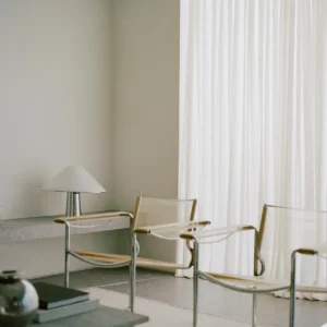 White sheer curtains behind lounge chairs in a waiting area, Dubai